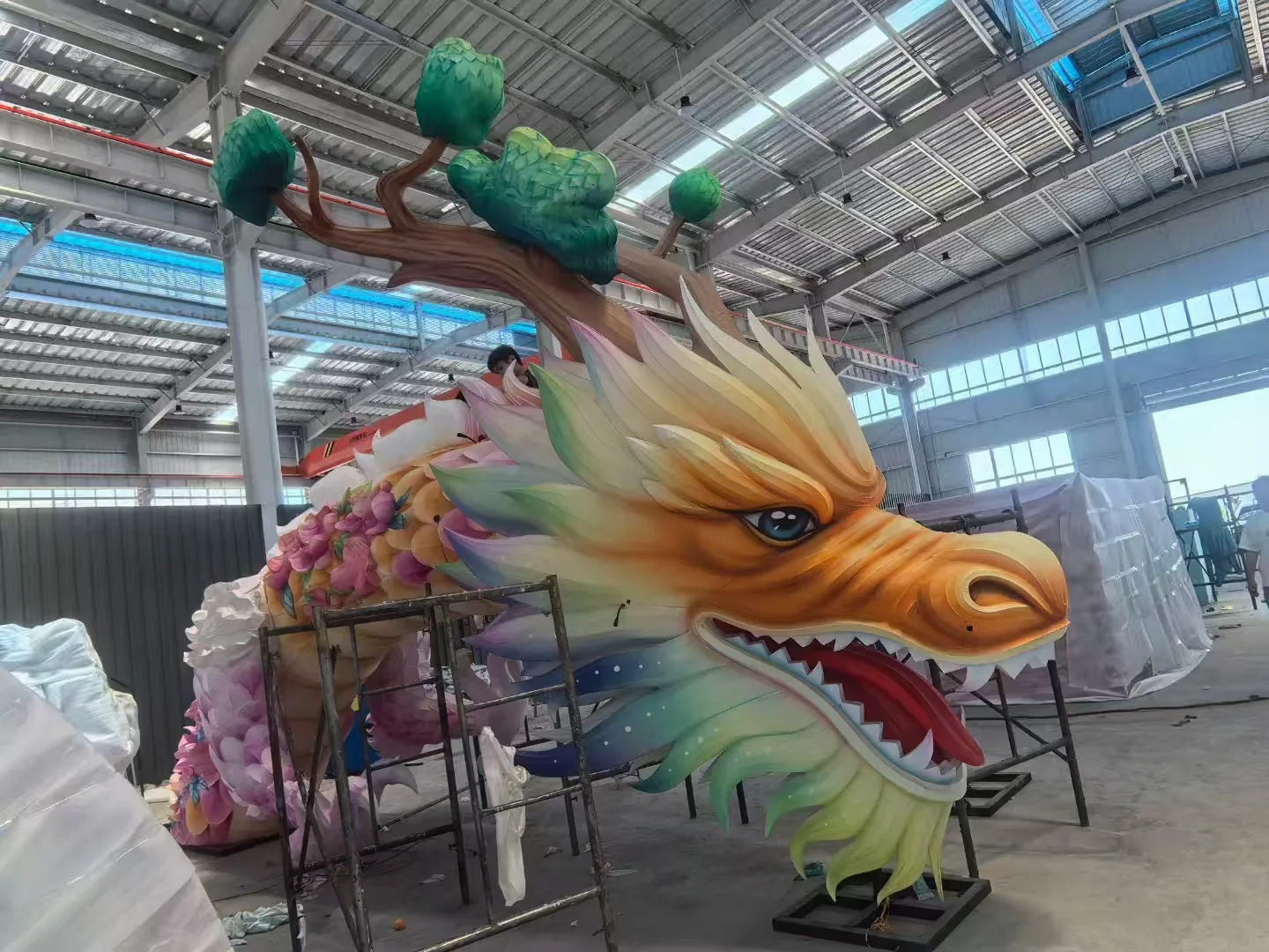 Dragon lantern head being assembled with scaffolding in the workshop