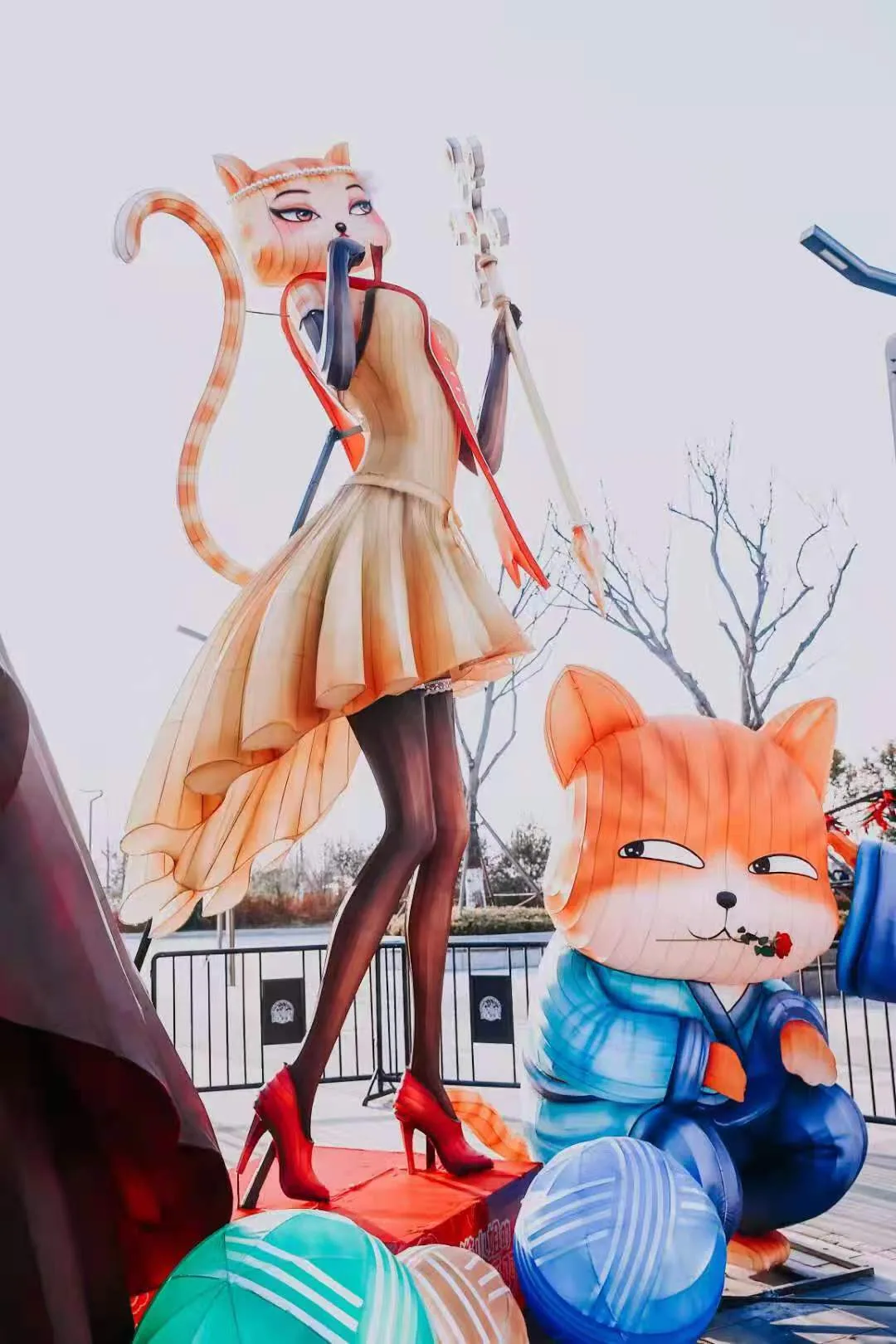 Tall Miss Cat figure with a seated cat lantern during daytime