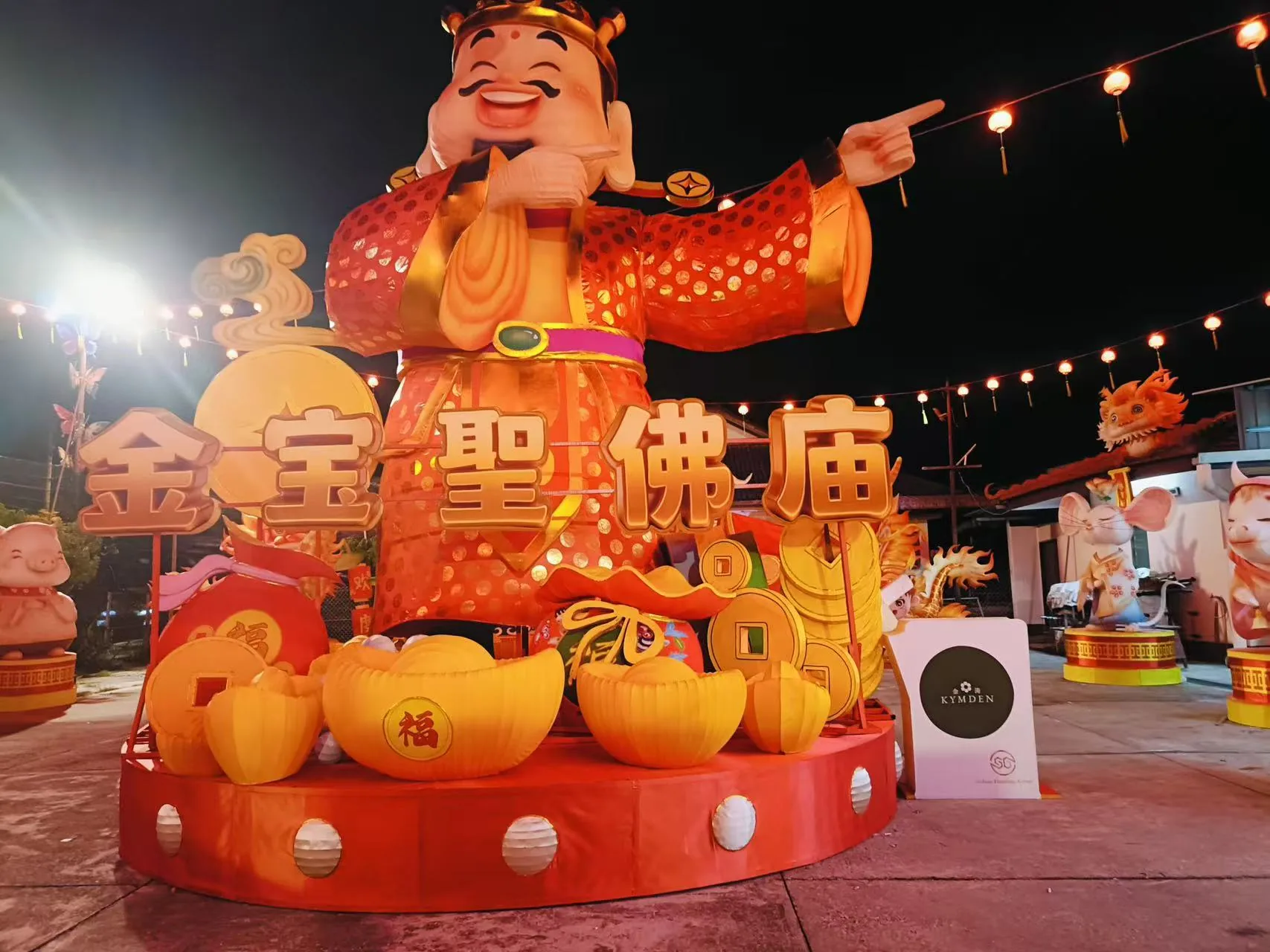 Illuminated God of Wealth lantern centerpiece at the Perak festival site