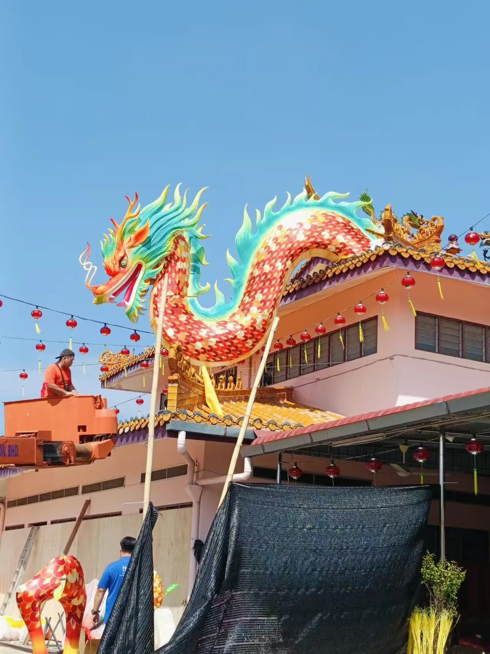 Installation crew lifting a dragon lantern into position