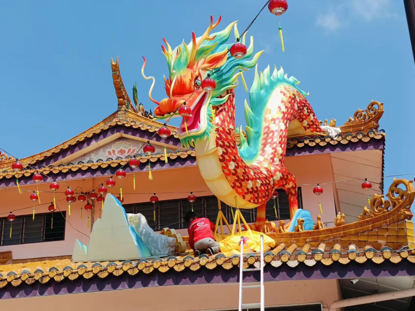 Dragon lantern being secured above the venue roofline