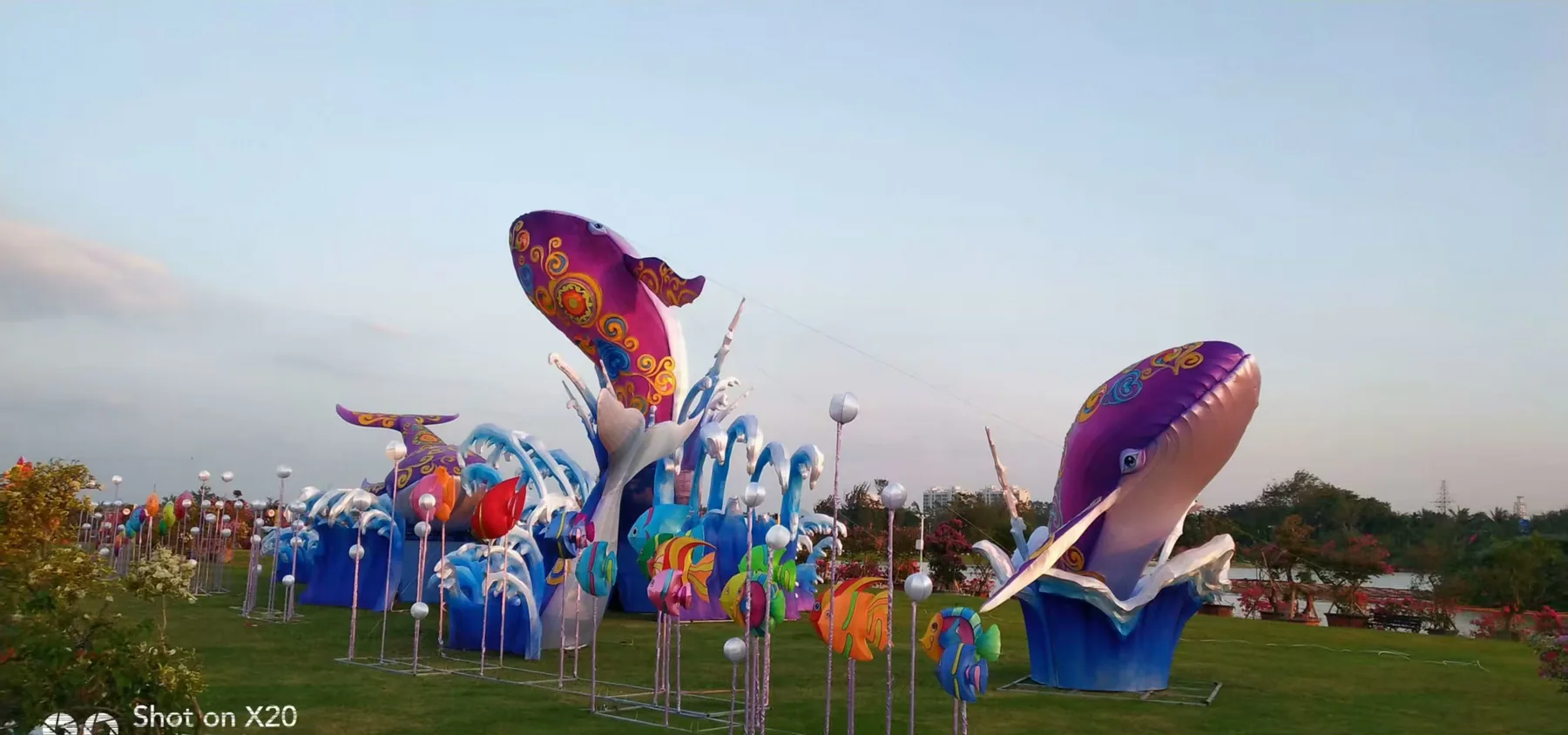 Whale and ocean themed lantern display installed in a green outdoor area